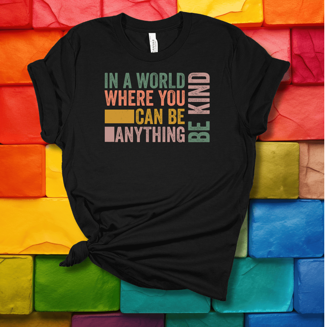 Printify T-Shirt Black Heather / S In a world where you can be anything...be kind!